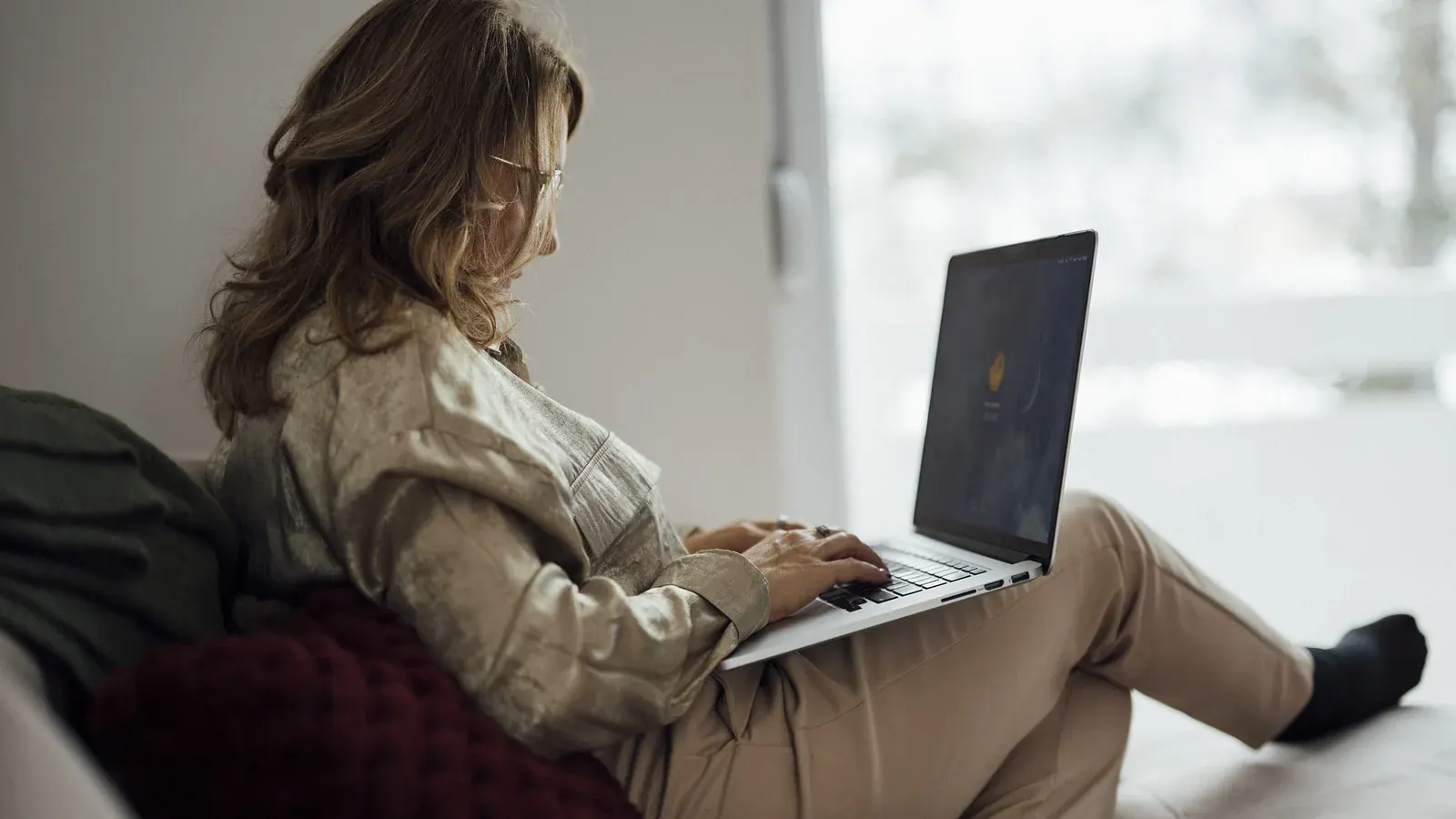 Woman sitting on a couch using a laptop in a living room