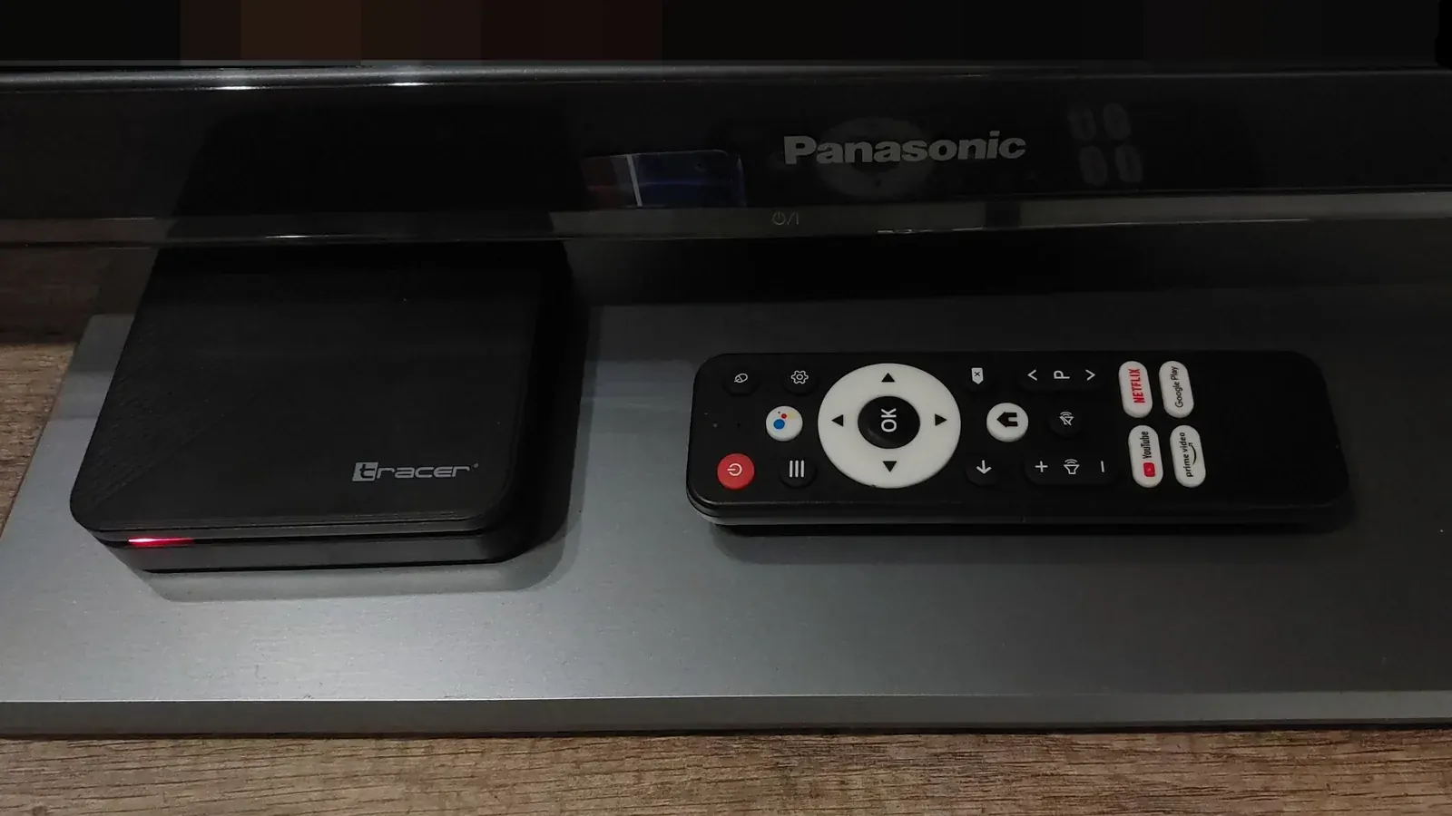 Android TV set-top box and remote control next to a television