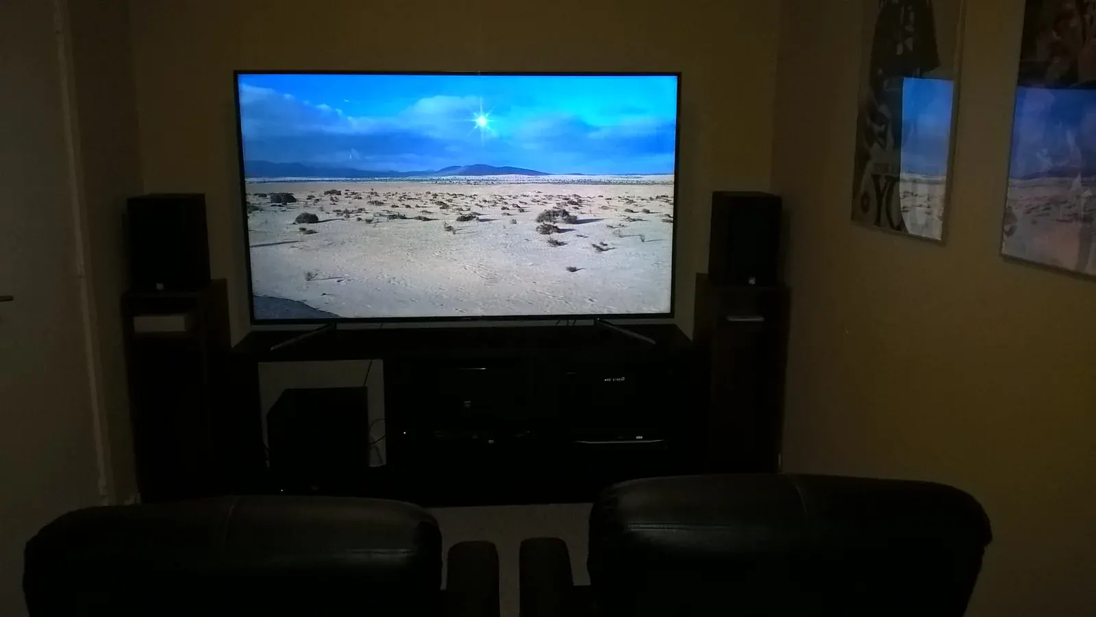 Home theater room with a large television and framed movie posters