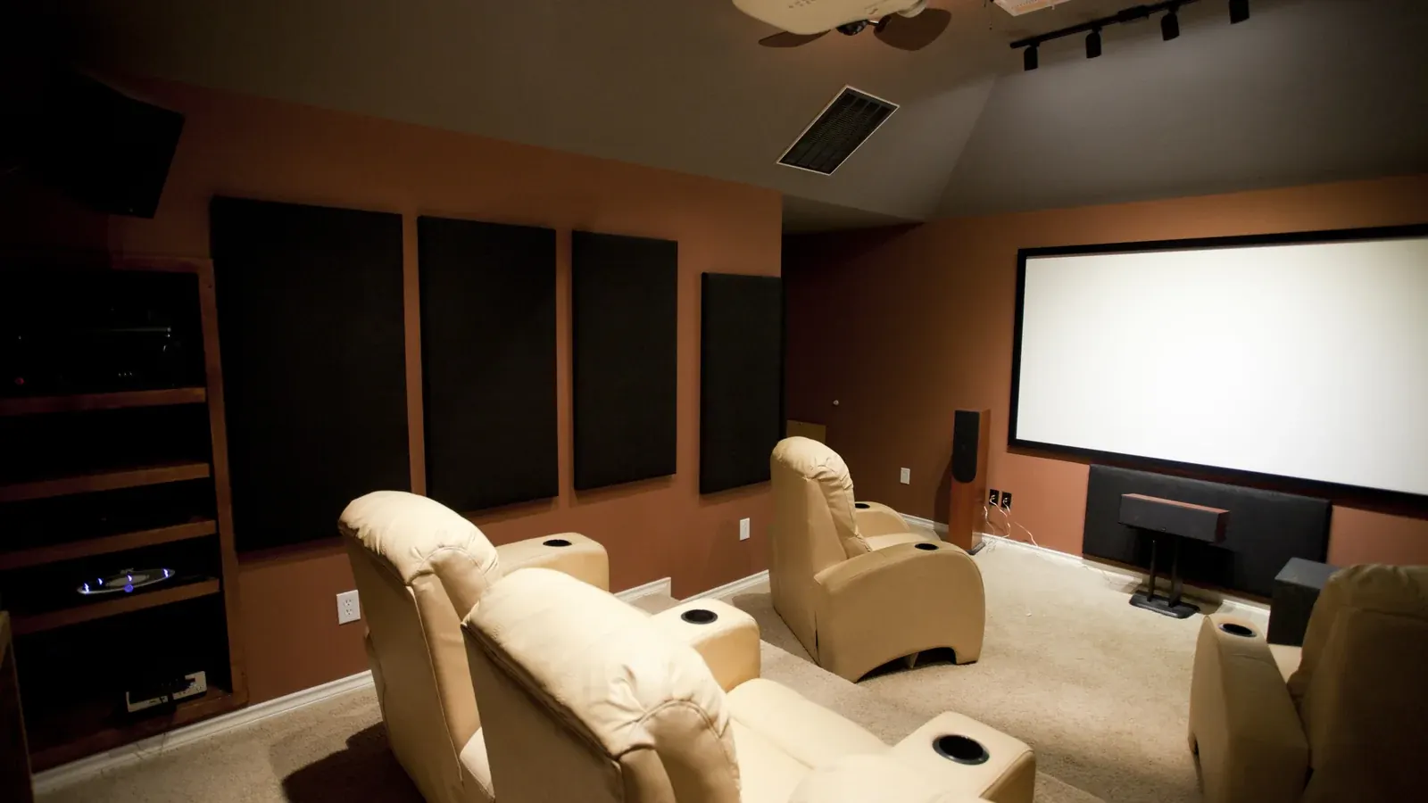 Dedicated home theater room with a large screen and theater seating
