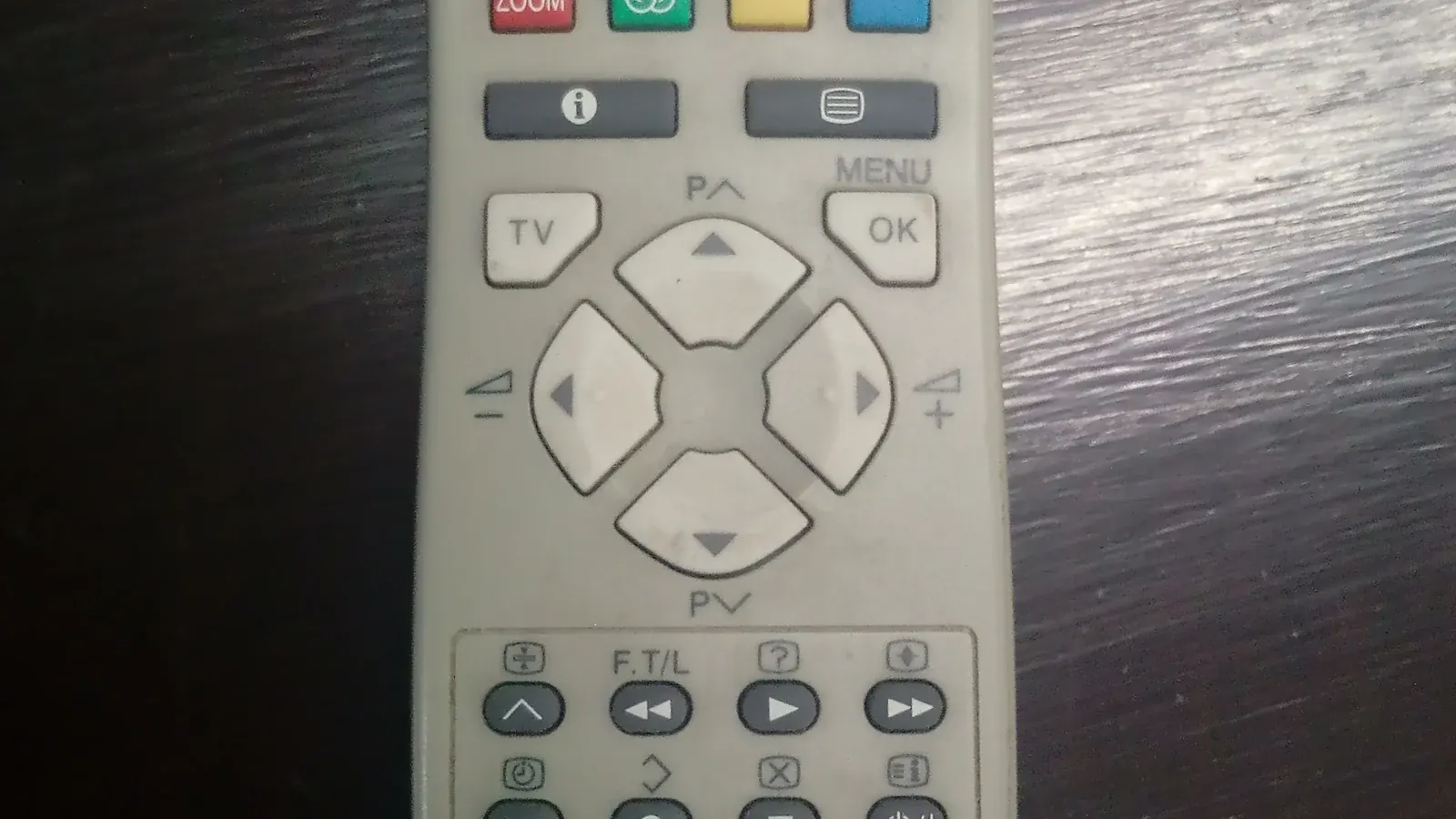 Close-up of a TV remote control with menu and OK buttons